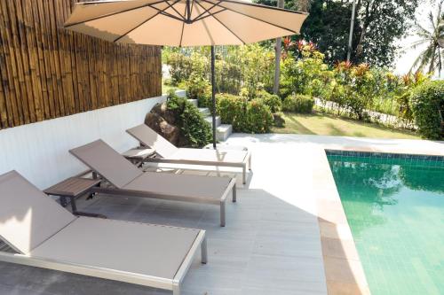 a patio with chairs and an umbrella next to a swimming pool at Baan Fah Sai in Koh Phangan