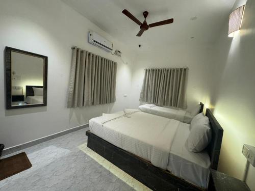 a bedroom with a bed with a ceiling fan and a mirror at La Tamara Suite - TIE Hotels & Resorts in Puducherry