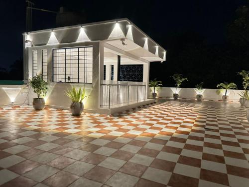a pavilion with potted plants on a checkered floor at La Tamara Suite - TIE Hotels & Resorts in Puducherry