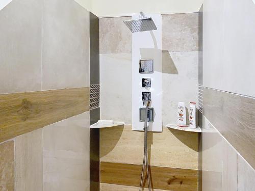 a bathroom with a shower with a glass wall at Résidence Verdi - Appartements meublés en centre ville in Bédarieux