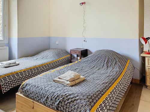 two twin beds in a room with at Résidence Verdi - Appartements meublés en centre ville in Bédarieux