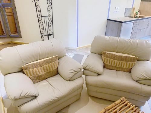 a white couch with two pillows in a living room at Résidence Verdi - Appartements meublés en centre ville in Bédarieux