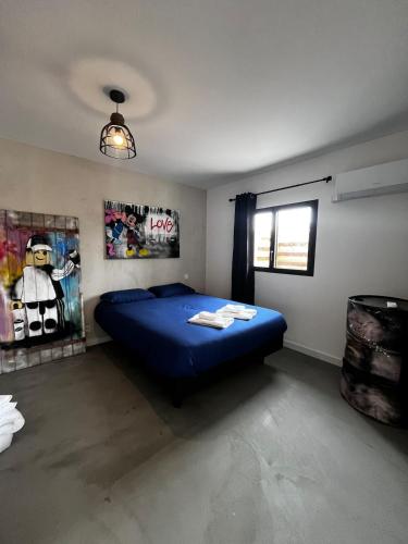 a bedroom with a blue bed and a window at La folie douce Jacuzzi et clim in Montauban