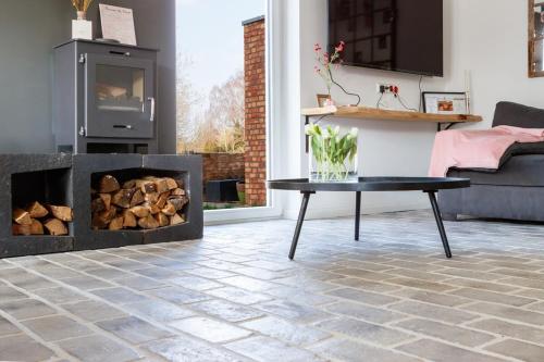 a living room with a fireplace and a table at Unieke landelijke woning met zwembad in Kranenburg