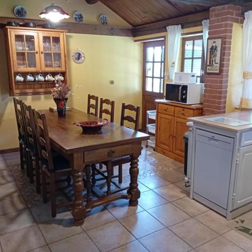 - une cuisine avec une table en bois, des chaises et une cuisinière dans l'établissement Peaceful Retreat, à Bessines-sur-Gartempe