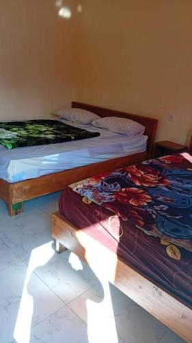two beds sitting next to each other in a room at Tengger Bromo Villa in Ngadisari