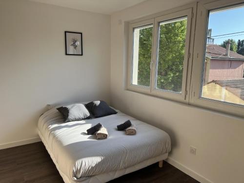 a bed in a room with a window at Résidence Claire Roman in Valence