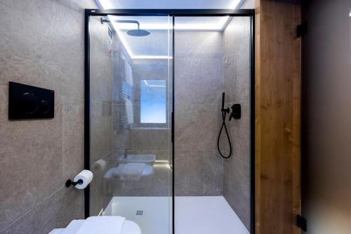 a bathroom with a glass shower with a toilet at Hotel Miralago in Misurina
