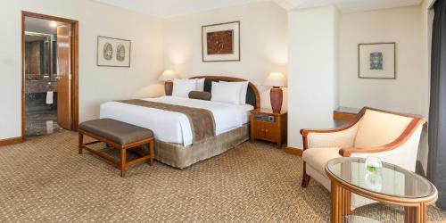 a hotel room with a bed and a table at Aryaduta Menteng in Jakarta