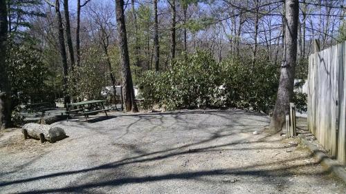 a park with a bench and a fence and trees at Linville Falls Campground, RV Park, and Cabins in Linville Falls
