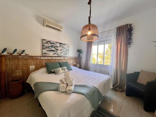a bedroom with a bed with towels on it at Casa Ibicenca - Precioso chalet con piscina in Peñíscola