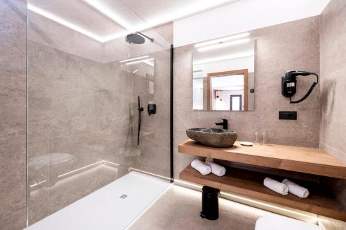 a bathroom with a sink and a shower at Hotel Miralago in Misurina