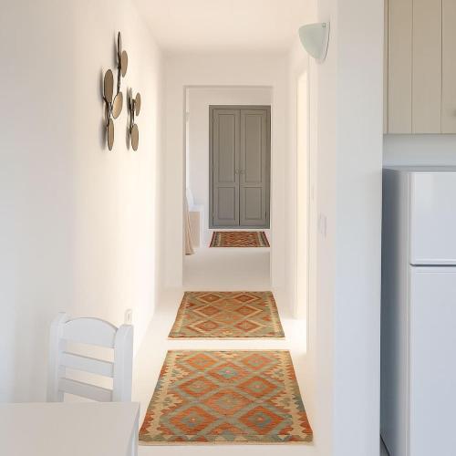 a hallway with white walls and a kitchen with a door at Moniasma Rustic Stone House in Folegandros in Ano Meria