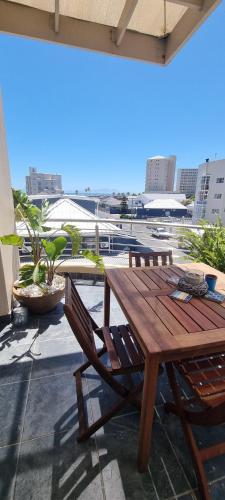 a wooden table and chairs on top of a building at Ocean Escape in Strand
