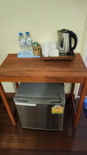 a wooden table with a printer and water bottles at Baan Khun ya Ayutthaya in Phra Nakhon Si Ayutthaya