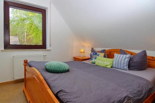 a bedroom with a bed with pillows and a window at FeWo 1 Am Sportplatz 2 in Ueckeritz