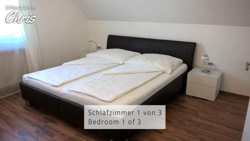 Bett mit schwarzem Rahmen sowie weißer Bettwäsche und Kissen in der Unterkunft Urlaub beim Chris in Untervogau