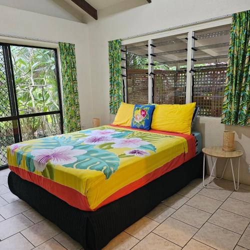 a bedroom with a bed in a room with windows at Mango Cottage with AC, Unlimited Wifi and Private pool in Rarotonga
