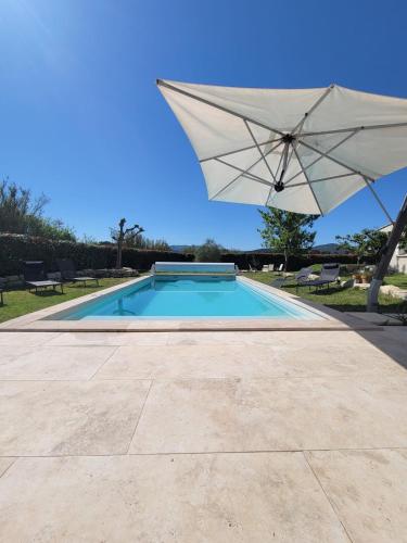- une piscine avec un parasol, des chaises et une table dans l'établissement Villa avec piscine et vue, à Vaison-la-Romaine