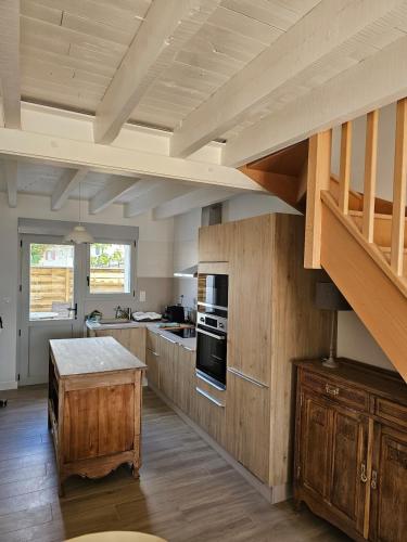 une grande cuisine avec des placards en bois et un escalier dans l'établissement Le 6 - B Saint Xandre, à Saint-Xandre