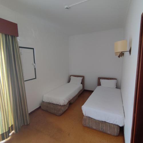 a room with two beds and a window in it at Hotel Irmãs Dominicanas - Fátima by Flagworld Hotels in Fátima