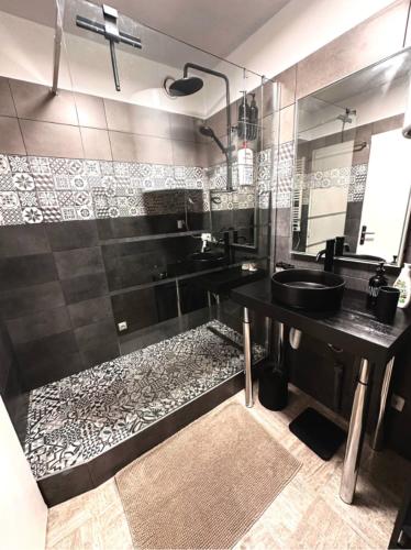 une salle de bain avec un lavabo noir et un miroir dans l'établissement Appart Hotel Paris Cosy Apartment Paris 12eme Gare de Lyon Bercy, à Paris