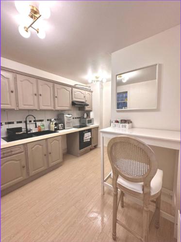 une cuisine avec un comptoir, une table et une chaise dans l'établissement Appart Hotel Paris Cosy Apartment Paris 12eme Gare de Lyon Bercy, à Paris