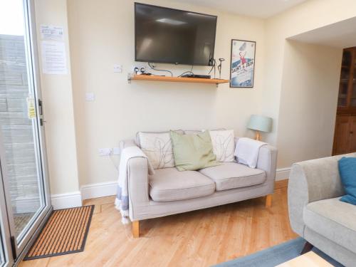 a living room with a couch and a flat screen tv at The Quarterdeck in Porthmadog