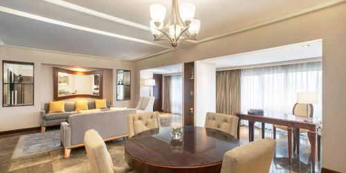 a living room with a dining table and a couch at Aryaduta Menteng in Jakarta