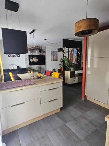 Il comprend une cuisine avec des placards blancs et une télévision murale. dans l'établissement Maison avec deux chambres, un jardin et une terrasse, à Vannes