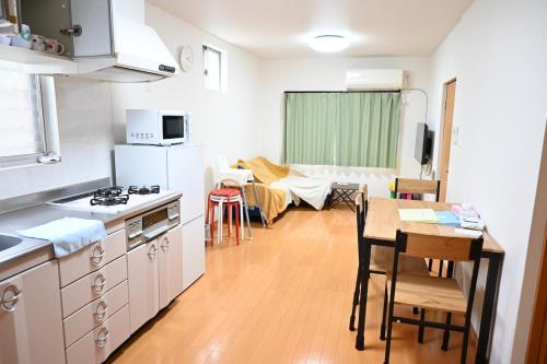 una pequeña cocina con mesa y comedor en Ko's HOUSE Shinmori7, en Osaka