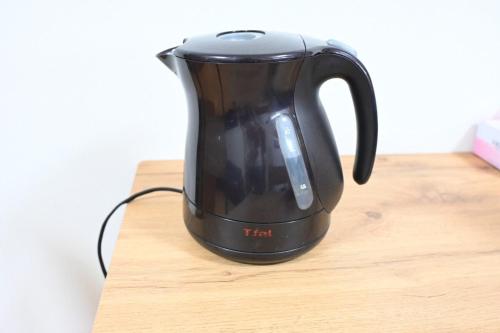 a black tea kettle sitting on a wooden table at Ko's HOUSE Shinmori7 in Osaka