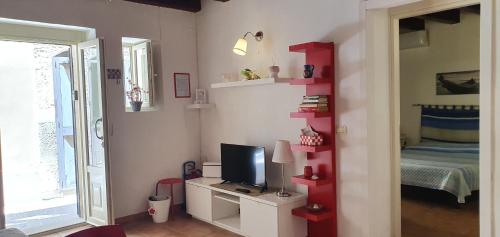 a living room with a tv and a red shelf at Appartamento Aretusa in Siracusa