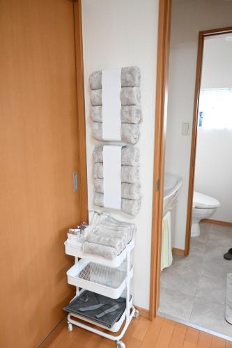 a pile of towels on a towel rack in a bathroom at Ko's HOUSE Shinmori7 in Osaka