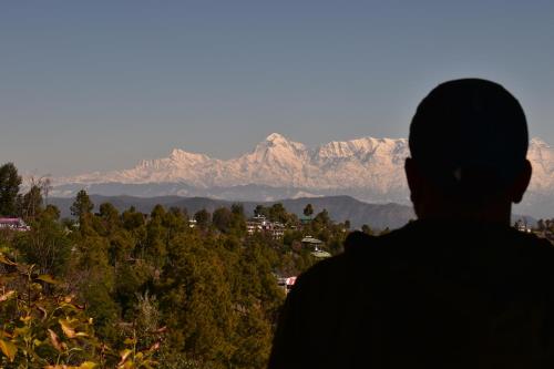 a person looking out at a mountain range at RUDRA Retreat in Hawālbāgh