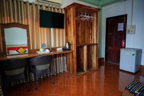 a room with a bar with chairs and a refrigerator at Vang Vieng Mountain View Hotel in Vang Vieng