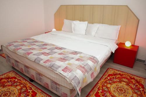 a bedroom with a large bed with two rugs at Hotel Bucovina in Suceava