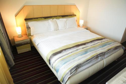 a large bed in a hotel room with two lamps at Hotel Bucovina in Suceava