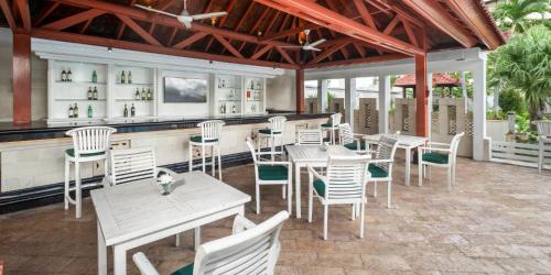 a restaurant with white chairs and tables and a bar at Aryaduta Menteng in Jakarta