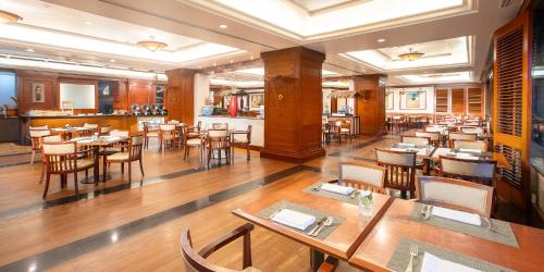 a restaurant with tables and chairs in a room at Aryaduta Menteng in Jakarta