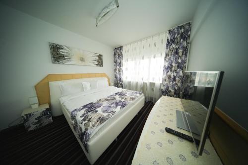 a small bedroom with a bed and a window at Hotel Bucovina in Suceava