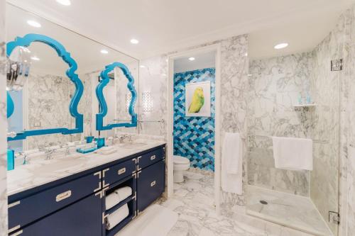 a blue and white bathroom with a sink and a shower at Eau Resort & Spa in South Palm Beach