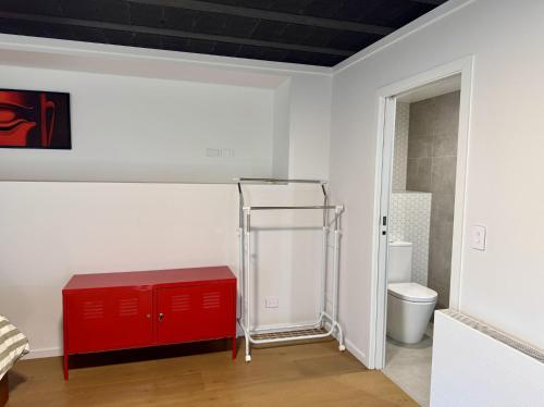 baño con armario rojo y aseo en Wanaka Matai Studio, en Wanaka
