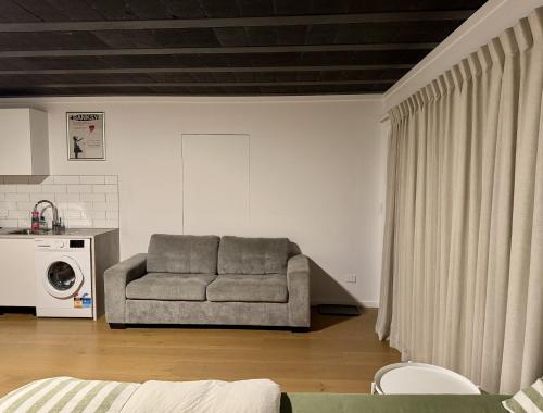 Una sala de estar con un sofá y un microondas. en Wanaka Matai Studio, en Wanaka