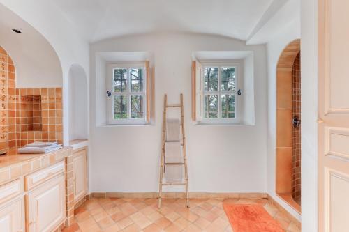 une cuisine avec une échelle et deux fenêtres dans l'établissement Sainte-Maxime - Villa de standing avec piscine & vue mer, à Sainte-Maxime