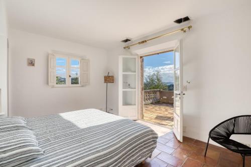 - une chambre avec un lit et une porte donnant sur un balcon dans l'établissement Sainte-Maxime - Villa de standing avec piscine & vue mer, à Sainte-Maxime