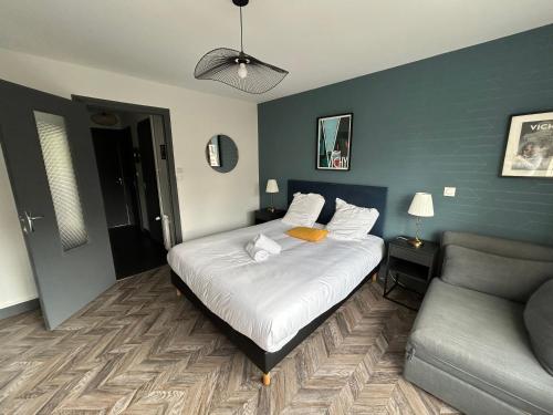 une chambre avec un lit et un canapé dans l'établissement Appartement prince de galles, à Vichy