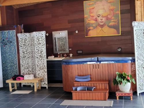 La salle de bains est pourvue d'une grande baignoire et d'un lavabo. dans l'établissement La Belle Demeure, à Aumagne