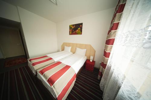 a small bed in a room with a window at Hotel Bucovina in Suceava