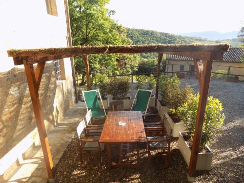 a wooden table and chairs under a pergola at Tenuta della Selva in Murlo